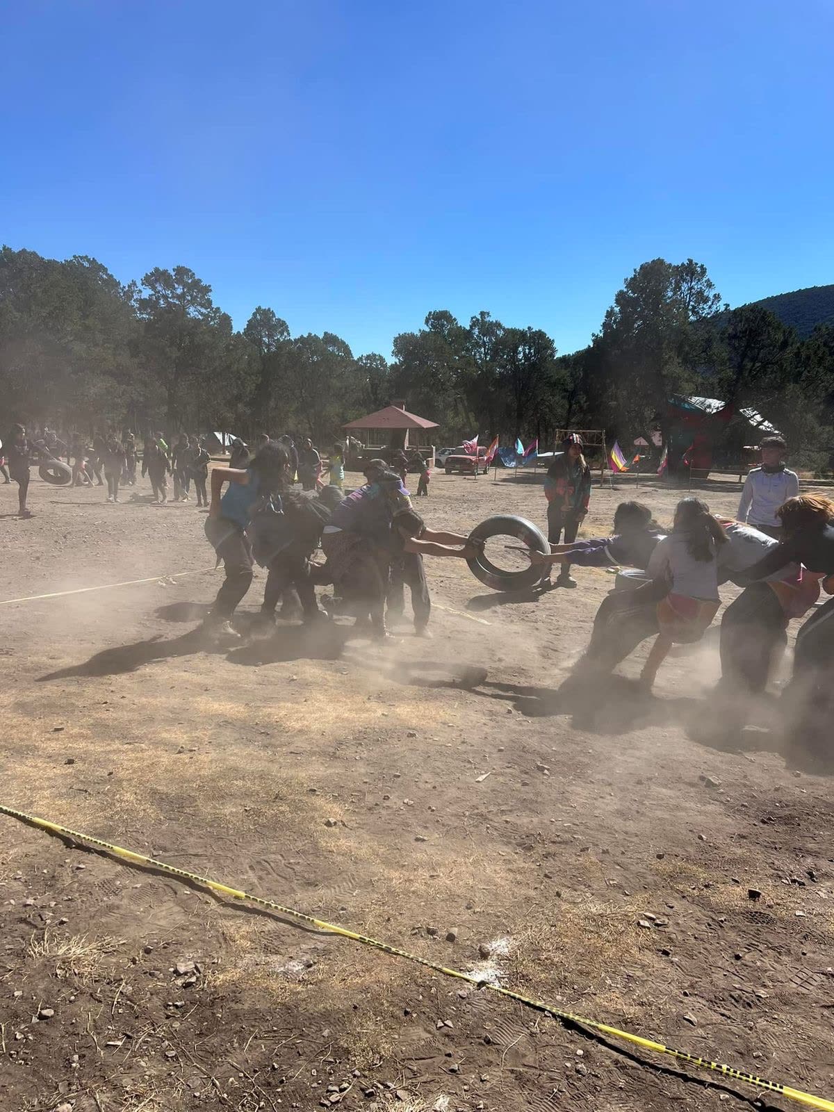 Jóvenes jugando tiro de llanta en un campamento
